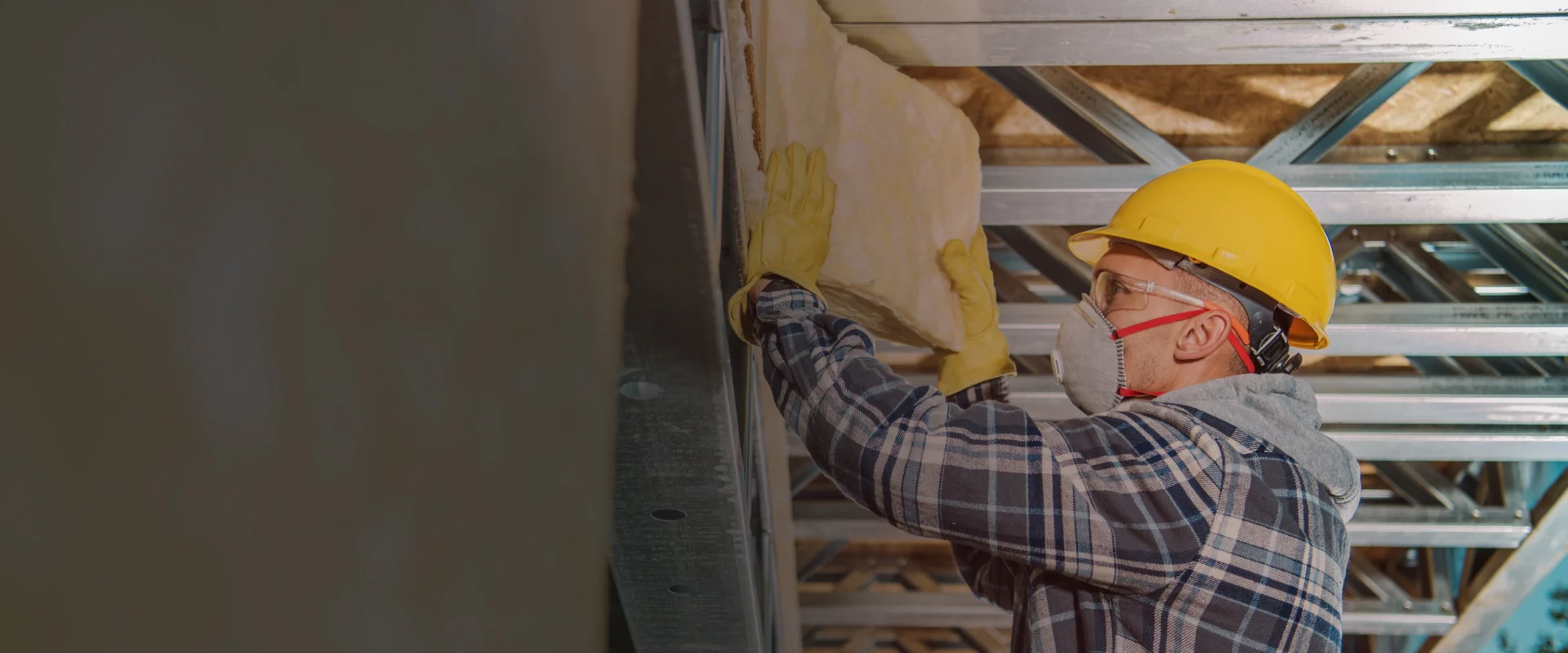 man installing insulation on a wall